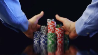 siyah arka plan üzerine kazandıktan sonra poker fişleri alarak eller