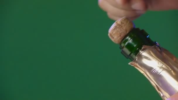 Άνθρωπος ανοίξετε το μπουκάλι σαμπάνιας σε πράσινο φόντο — Αρχείο Βίντεο