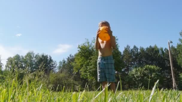 Caucásico chico jugando con pelota en un caluroso día de verano — Vídeo de stock