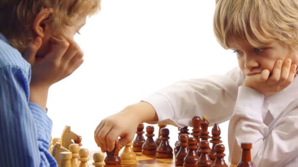 Zwei Jungen denken und spielen Schach — Stockvideo