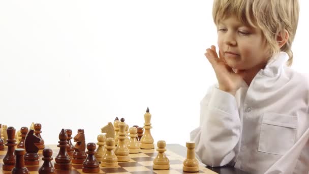 Pequeño niño juega ajedrez — Vídeo de stock