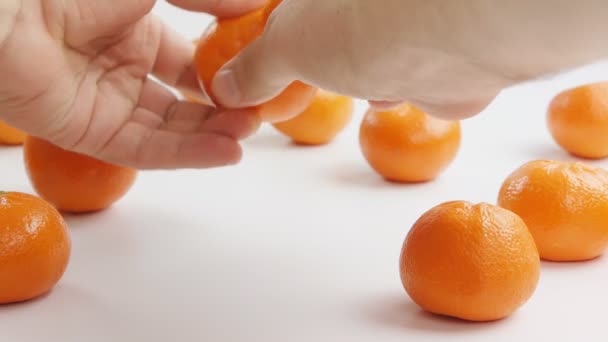 Man clears mandarin of a peel — Stock Video