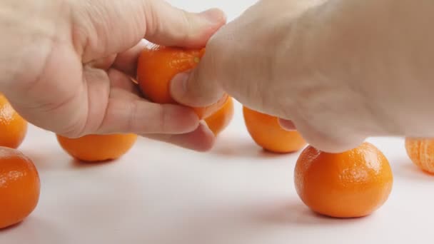 Man clears tangerine of a peel — Stock Video