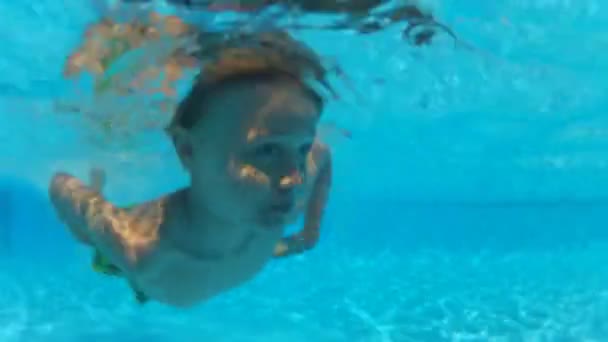 Niño nadando bajo el agua una piscina — Vídeo de stock