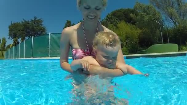 Madre con un bebé en una piscina — Vídeo de stock