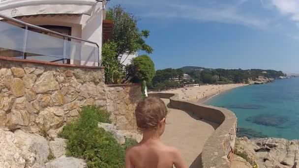 Boy walking along the seashore — Stock Video