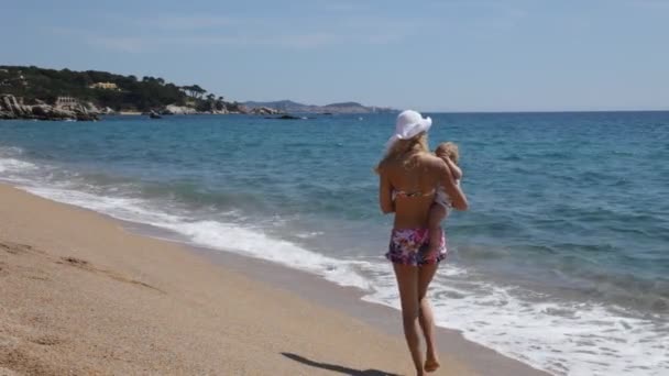 Мама и ребенок прогуливаются по берегу моря — стоковое видео