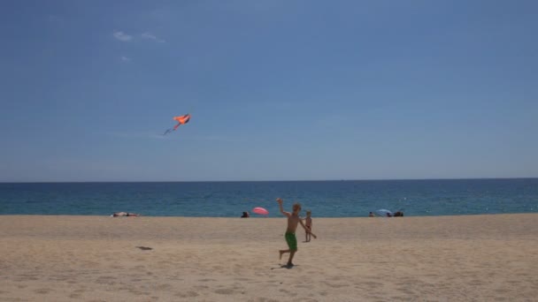 Glada pojkar flyger en drake på stranden — Stockvideo