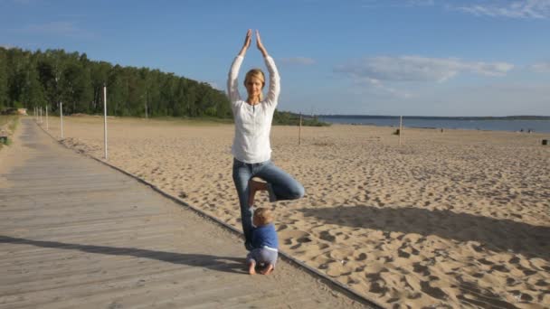 Mujer practicando yoga con su bebé — Vídeo de stock
