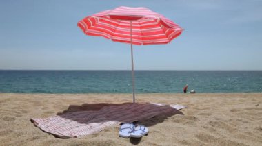 Mat ve flip flop'lar plaj şemsiyesi altında