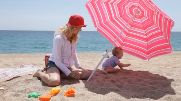 Mamma med sin bebis på stranden — Stockvideo