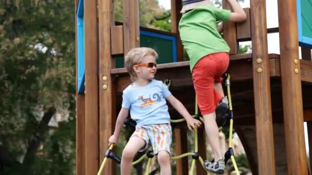 Boys getting down from wooden building — Stock Video