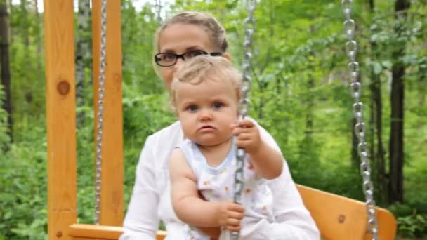 O bebê com sua mãe montar em um balanço — Vídeo de Stock