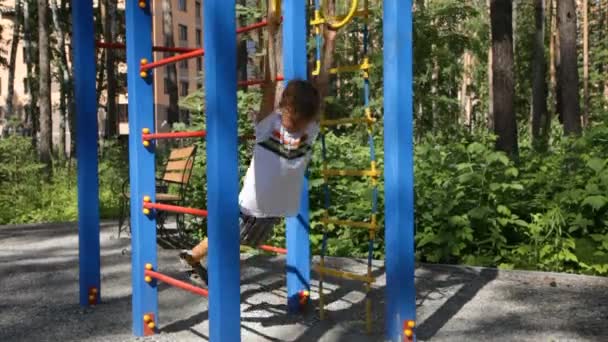 Niño jugando en el patio público — Vídeos de Stock