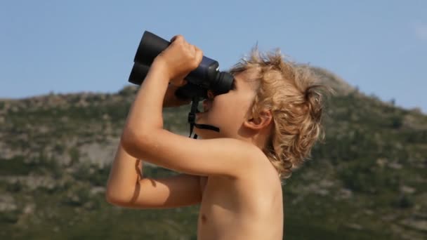 男孩透过双筒望远镜看 — 图库视频影像