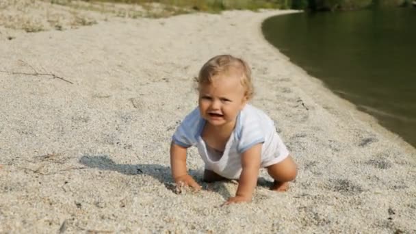 Little baby playing on a bank of a river — Stock Video