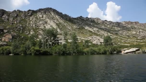 Montando ao longo de um lago de montanha — Vídeo de Stock