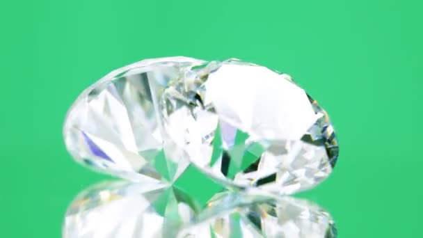 Twee diamanten op groene achtergrond — Stockvideo