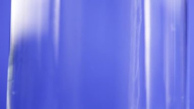 üzerinde mavi arka plan cam içine dökülen su