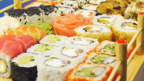 Delicious sushi rolls on wooden plate — Stock Video