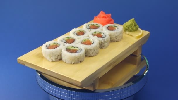 Delicious sushi rolls on wooden plate — Stock Video