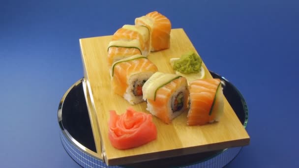 Delicious sushi rolls on wooden plate — Stock Video