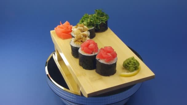 Delicious sushi rolls on wooden plate — Stock Video