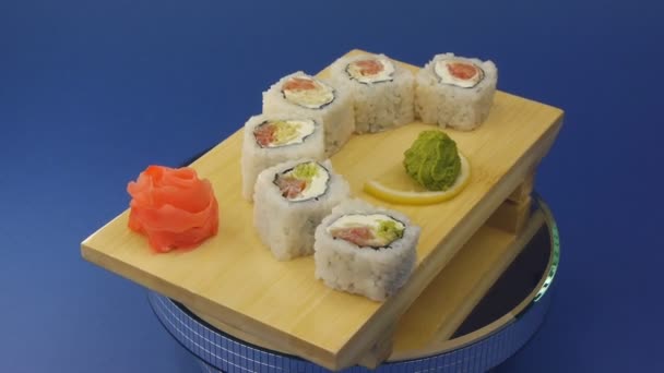 Delicious sushi rolls on wooden plate — Stock Video