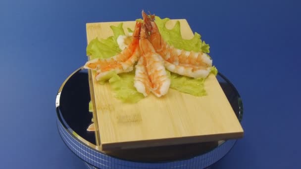 Креветки с зеленым салатом на деревянной тарелке — стоковое видео