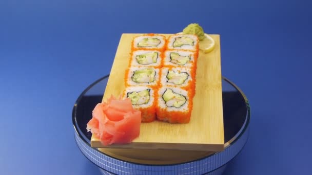 Rollos de sushi tradicionales servidos en plato de madera — Vídeos de Stock