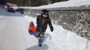 çocukların tepeden karda kayan