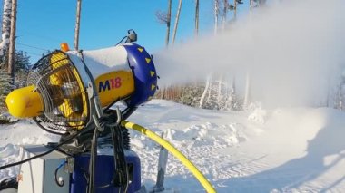 Kar yapma yamacında kar topu. Kar silahı, yapay buz kristalleri püskürtüyor. Makine kar yapıyor..