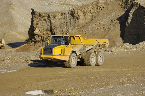 黄色のダンプトラックが鉱山で働いています — ストック写真