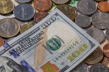 Farklı para birimlerinin üzerinde duran 100 dolarlık banknotu kapat.
