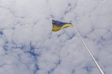 view on Ukrainian flag on flagpole against cloudy sky