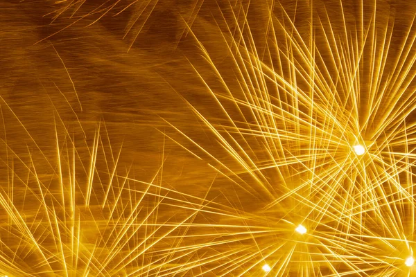 abstract holiday background: yellow fireworks in night sky