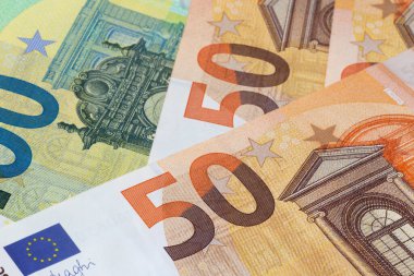 close up of several one hundred euro and fifty euro banknotes