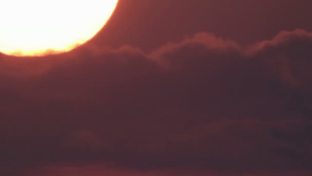 Яркий закат большого солнечного диска в облачном небе — стоковое видео