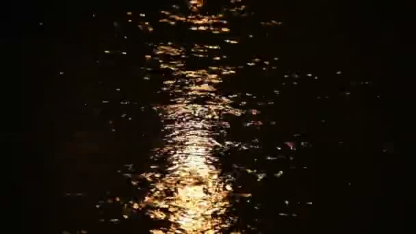 Luces amarillas reflejan en la superficie del agua — Vídeo de stock