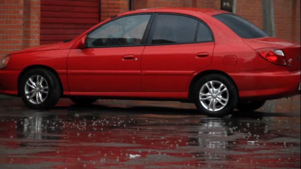 Coche rojo en estacionamiento bajo la lluvia — Vídeos de Stock