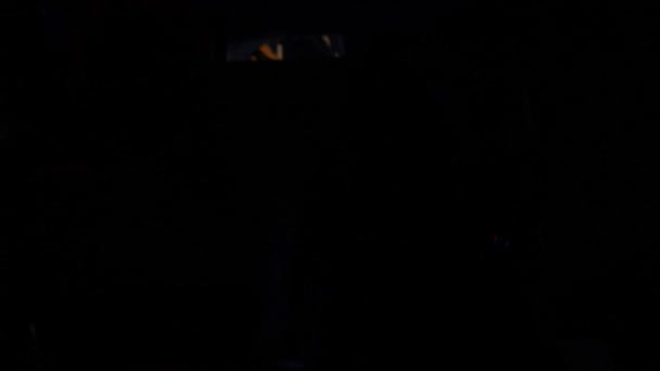 Silhuetas de pessoas que dançam na escuridão do clube noturno — Vídeo de Stock