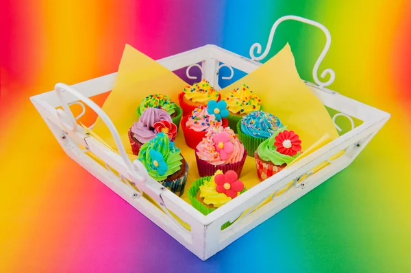 Colorful cupcakes on wooden tray — Stock Photo, Image