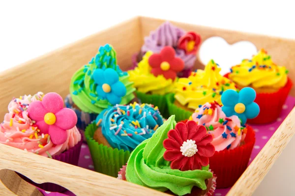 Colorful cupcakes on wooden tray — Stock Photo, Image