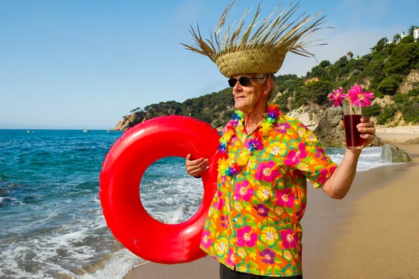 Старший чоловік з коктейльним напоєм на пляжі — стокове фото