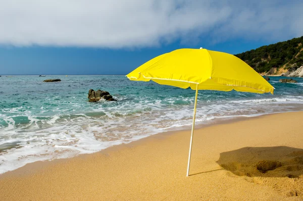 Gele parasol op het strand — Stockfoto