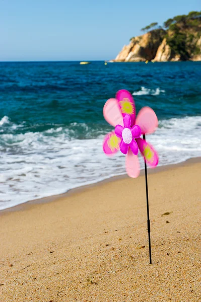 Іграшковий вітряний млин на пляжі — стокове фото