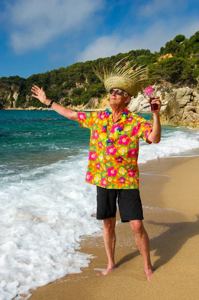 Senior man met cocktail drinken op het strand — Stockfoto