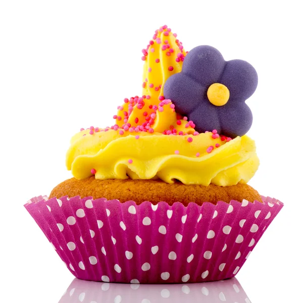 Pink cupcake with yellow cream and flower — Stock Photo, Image