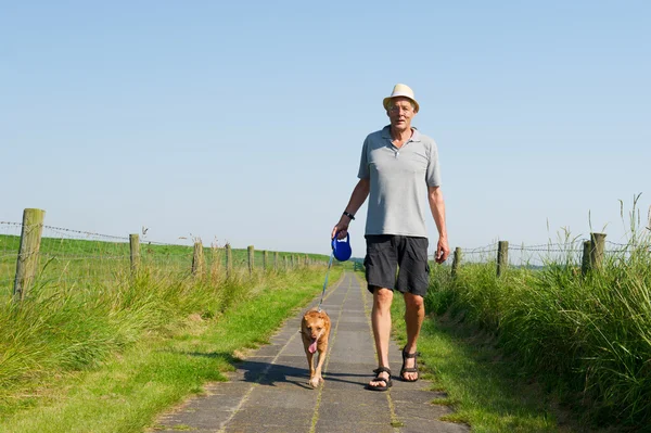 Äldre man gå ut med hunden — Stockfoto