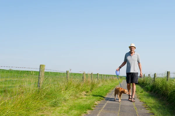 Elderly man walking the dog — Stock Photo, Image